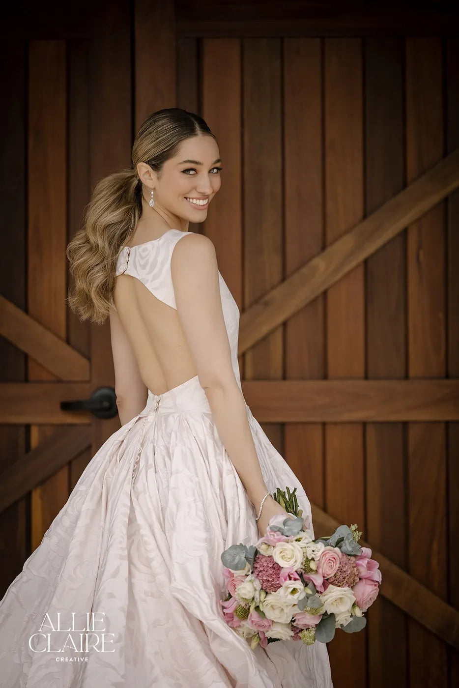 Bride with her bouquet at the barn doors