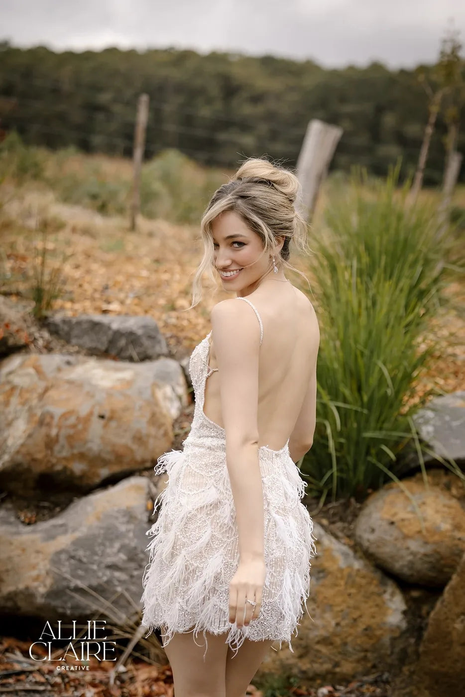 Bride by the stone wall, open-back gown