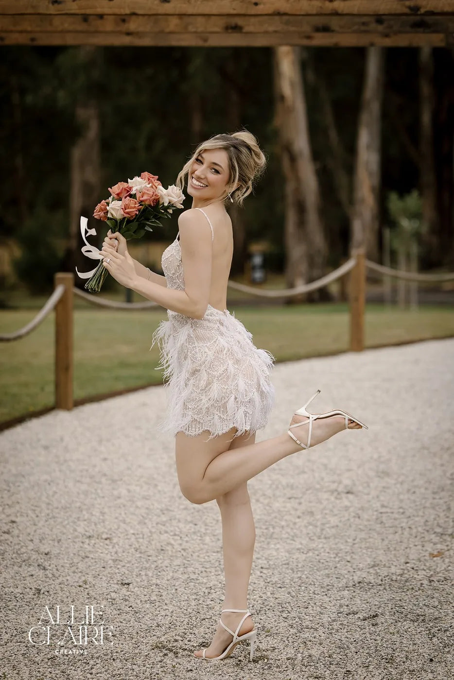 Bride under the timber pergola with her bouquet