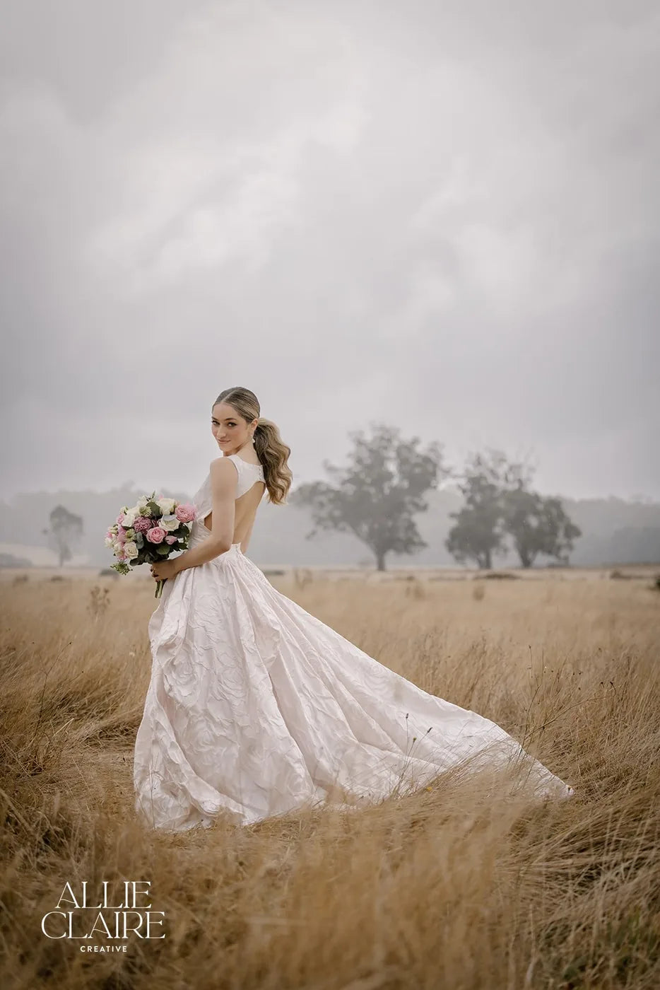 Bride in the field with her bouquet at golden hour