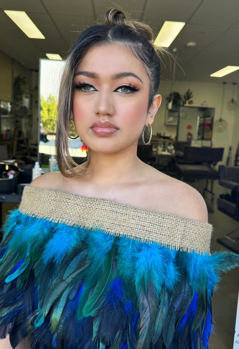 Client in a feathered gown with an evening makeup look